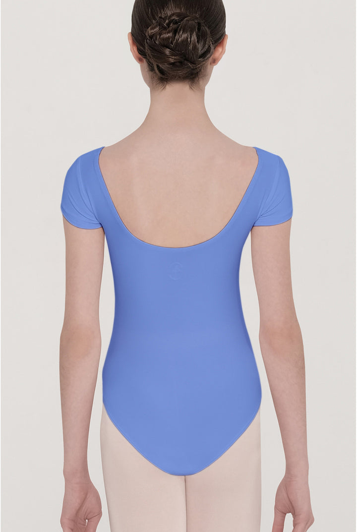 A model shown from the back wearing a short-sleeved blue leotard and light pink tights against a light gray studio background.