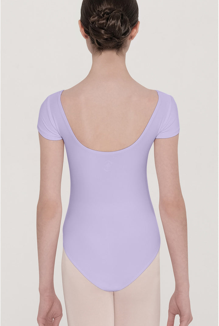A child model shown from the back wearing a lavender short-sleeve leotard and light beige tights against a plain light gray studio background.