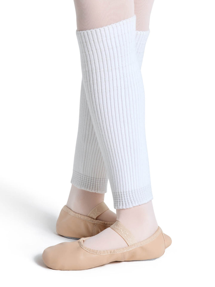Person wearing white leg warmers and beige ballet shoes on a white background