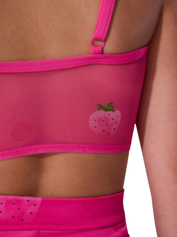 Close-up of a pink sports bra with strawberry design on a person wearing it.