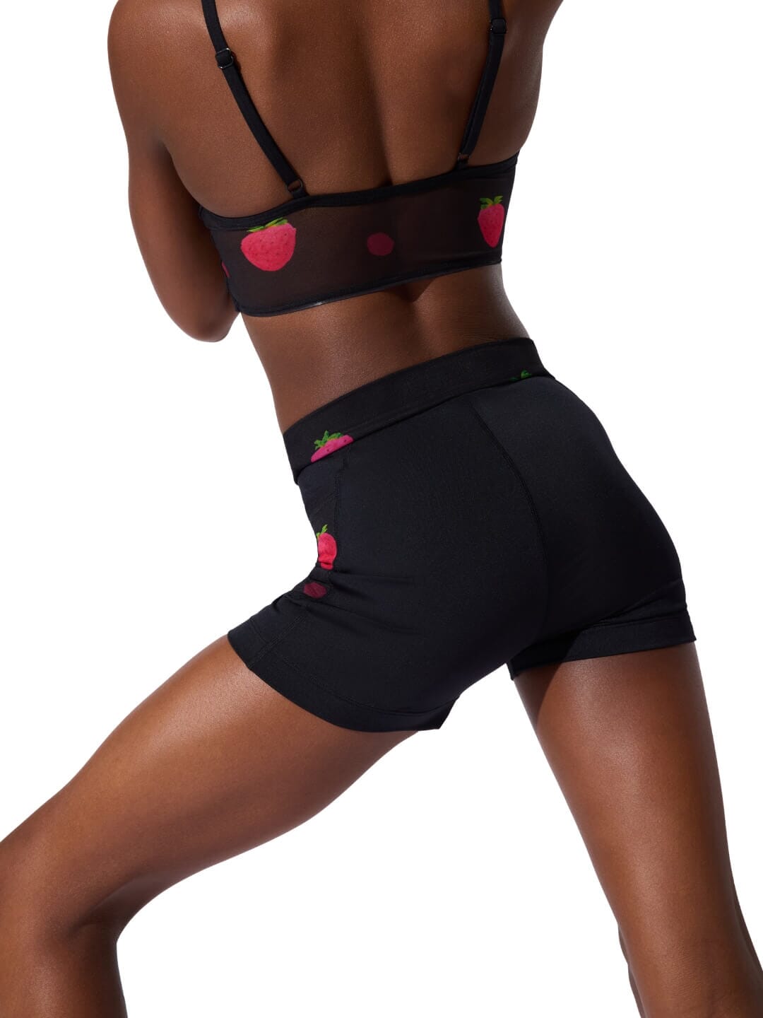 Black sports bra and shorts set with red heart designs on a white background