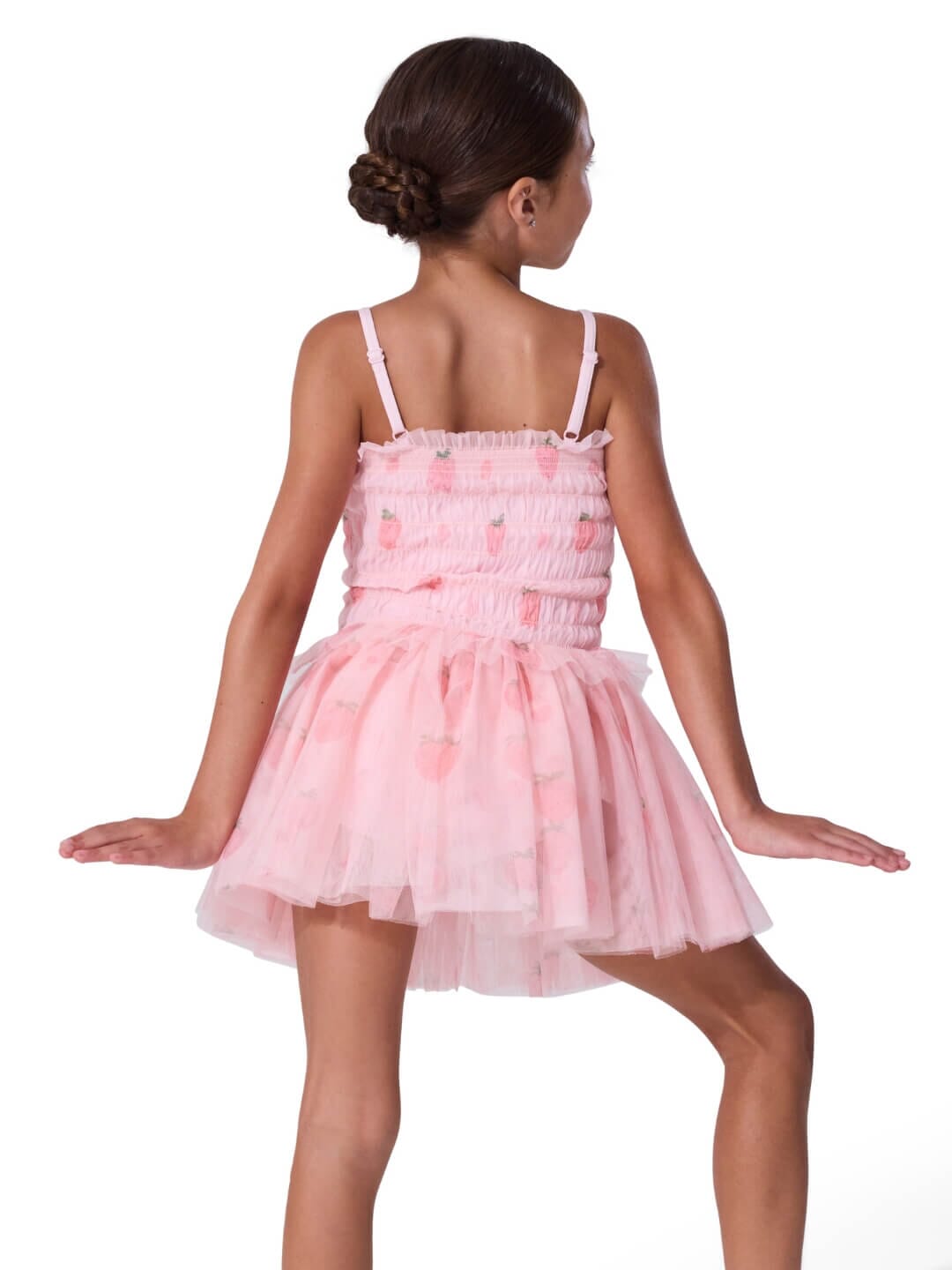 Young girl wearing a pink ballet dress on a white background