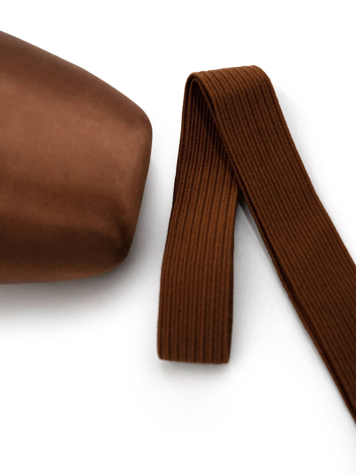 Brown ribbed belt and pouch on a white background