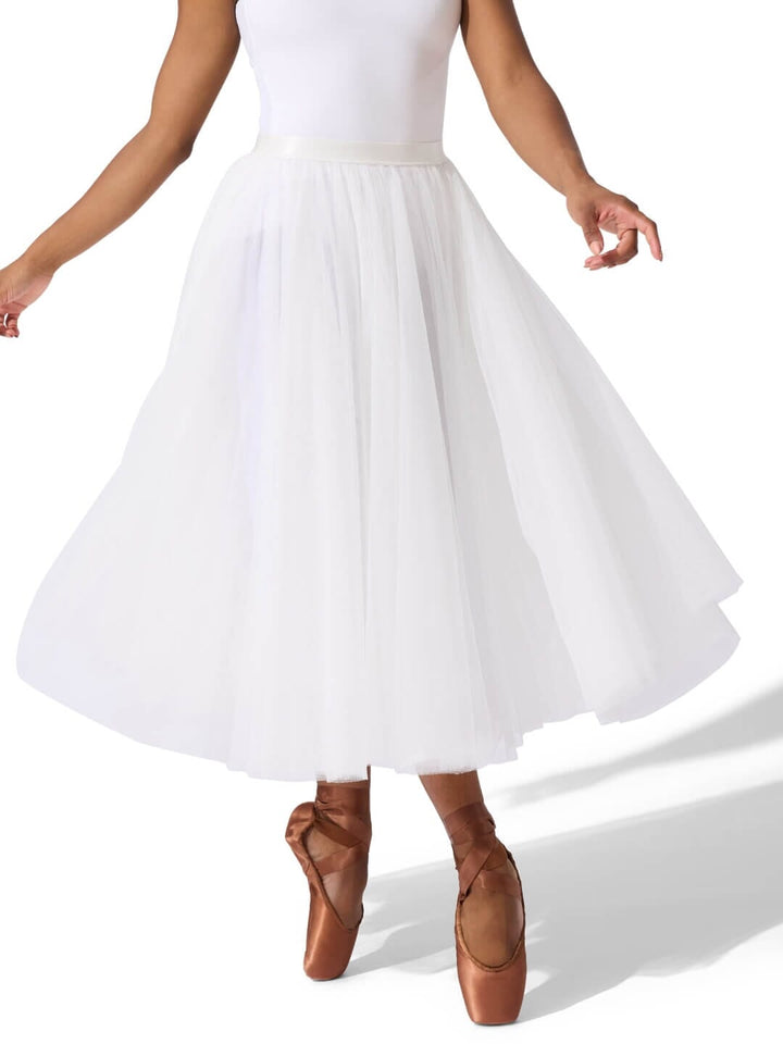 Person wearing a white skirt and brown ballet shoes on a white background