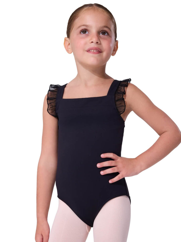 Young girl wearing a black leotard with sheer sleeves on a white background