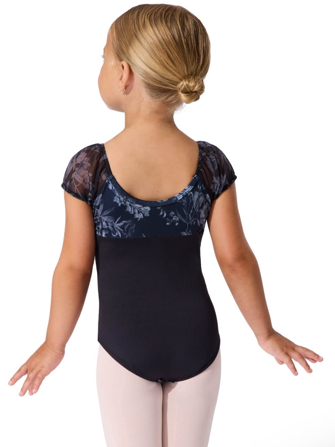 Child wearing a black leotard with floral lace sleeves on a white background