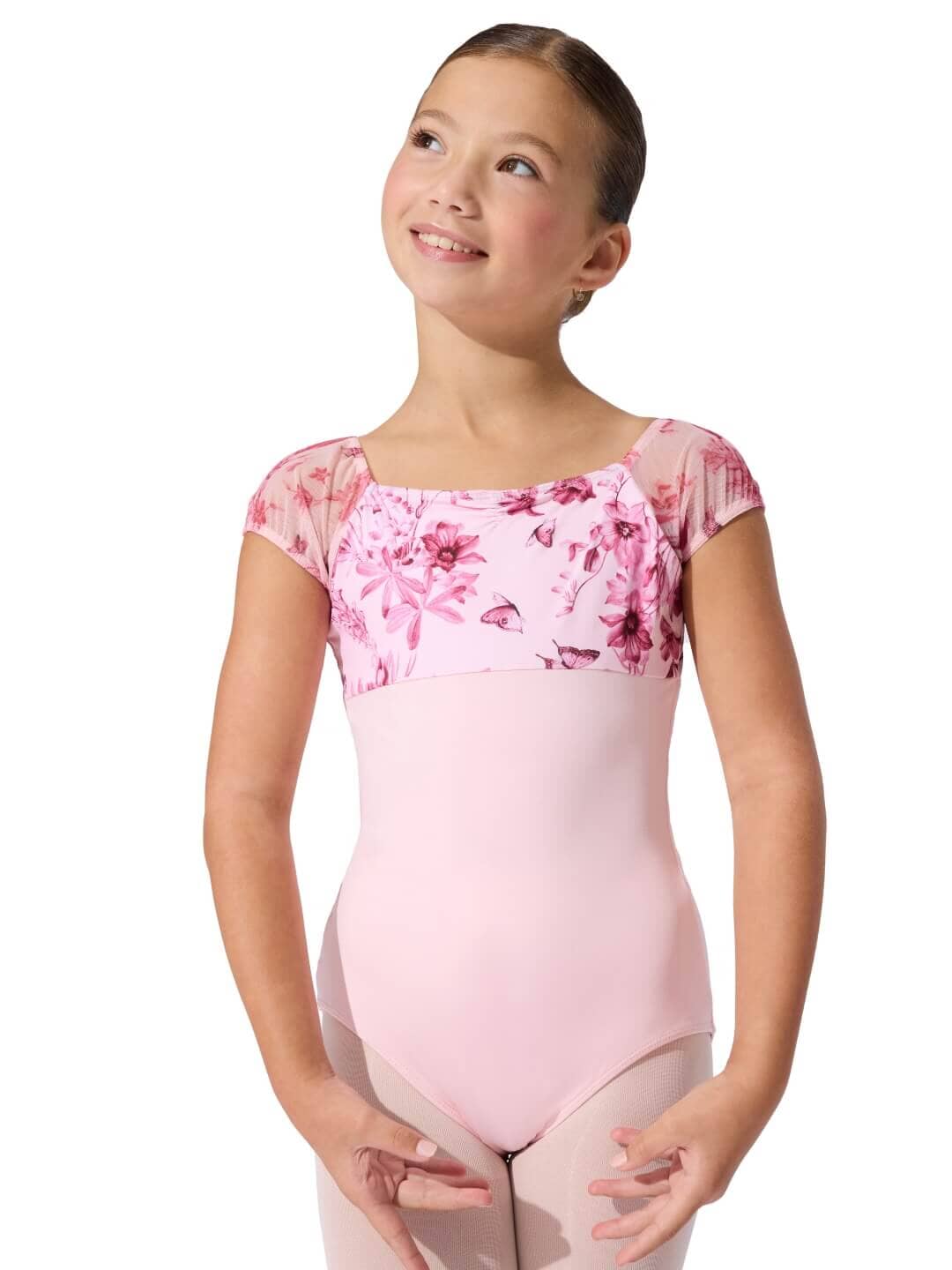 Young girl wearing a pink floral leotard on a white background