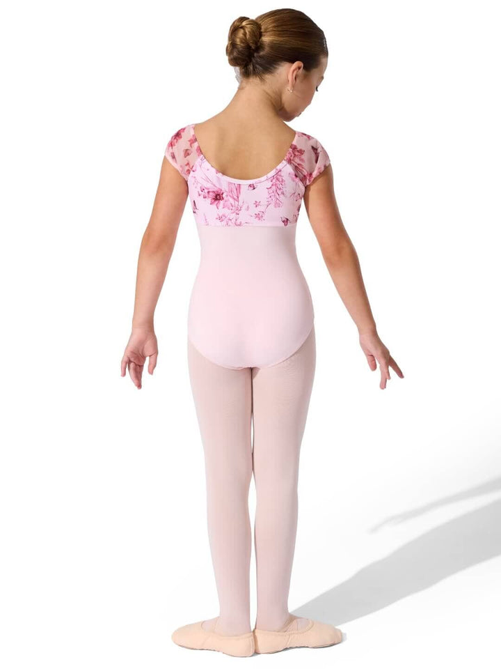 Young girl in a pink floral leotard and tights on a white background