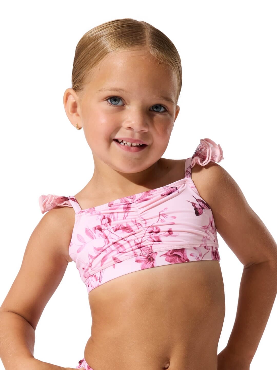 Young girl wearing a pink floral bikini against a white background