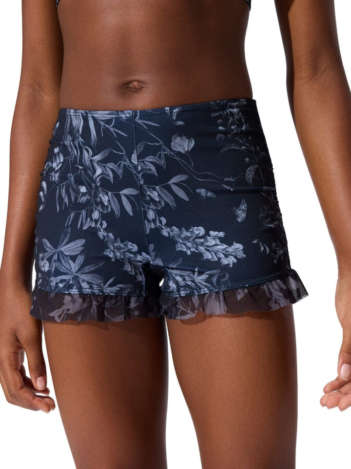 Navy floral shorts worn by a person on a white background