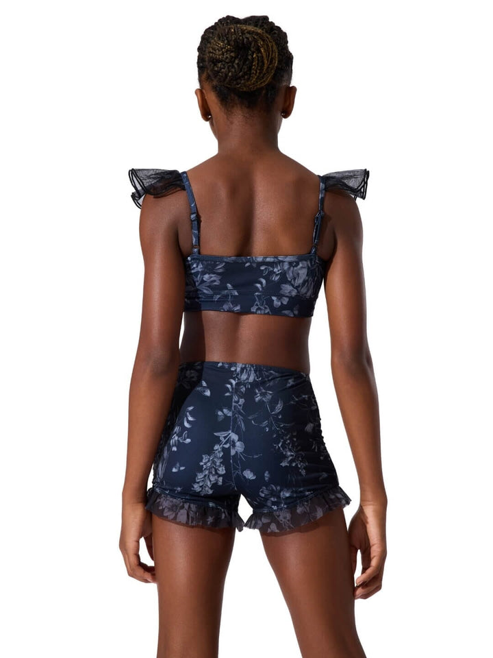 Woman wearing a navy floral two-piece outfit on a white background