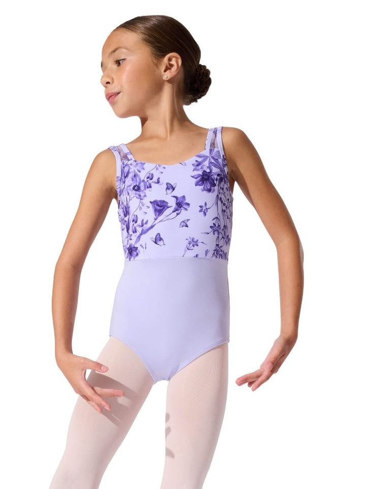 Young girl wearing a purple floral leotard on a white background