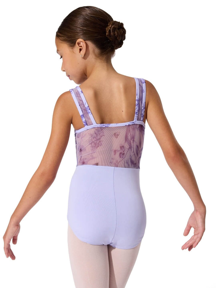 Ballet dancer wearing a lavender leotard with floral mesh back on a white background