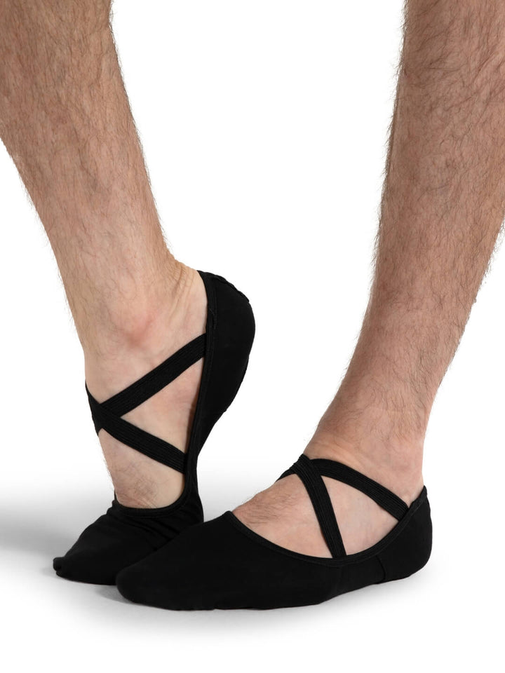 Black ballet-style socks with criss-cross straps worn by a person on a white background
