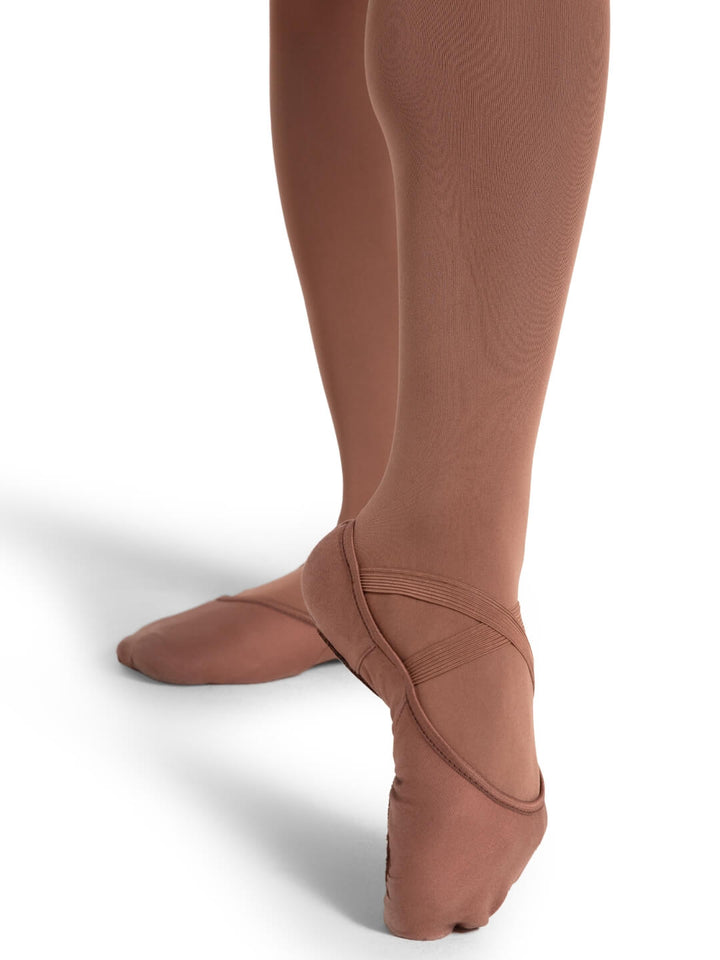 Brown tights worn with ballet shoes on a white background