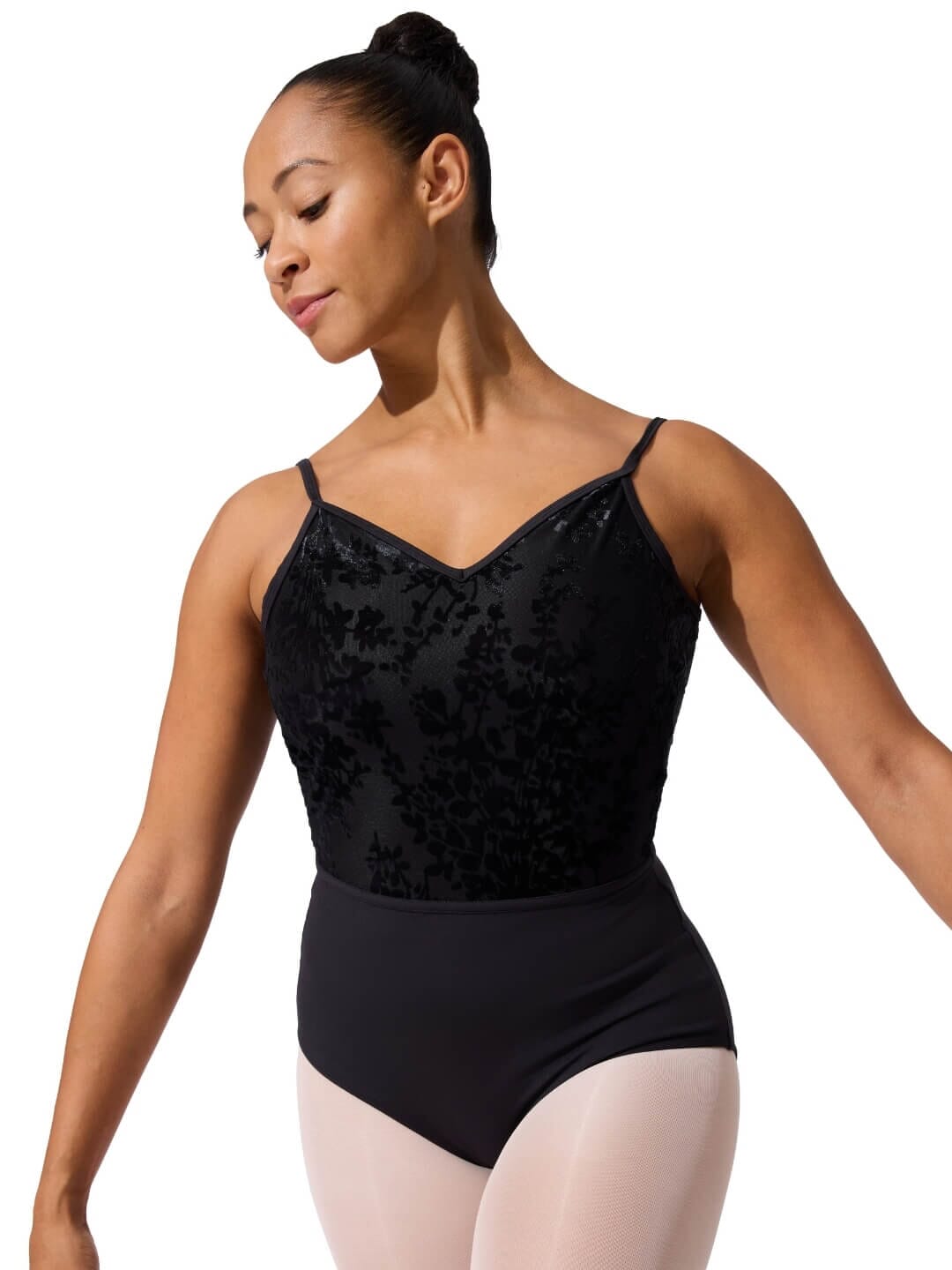 Woman wearing a black floral velvet leotard on a white background
