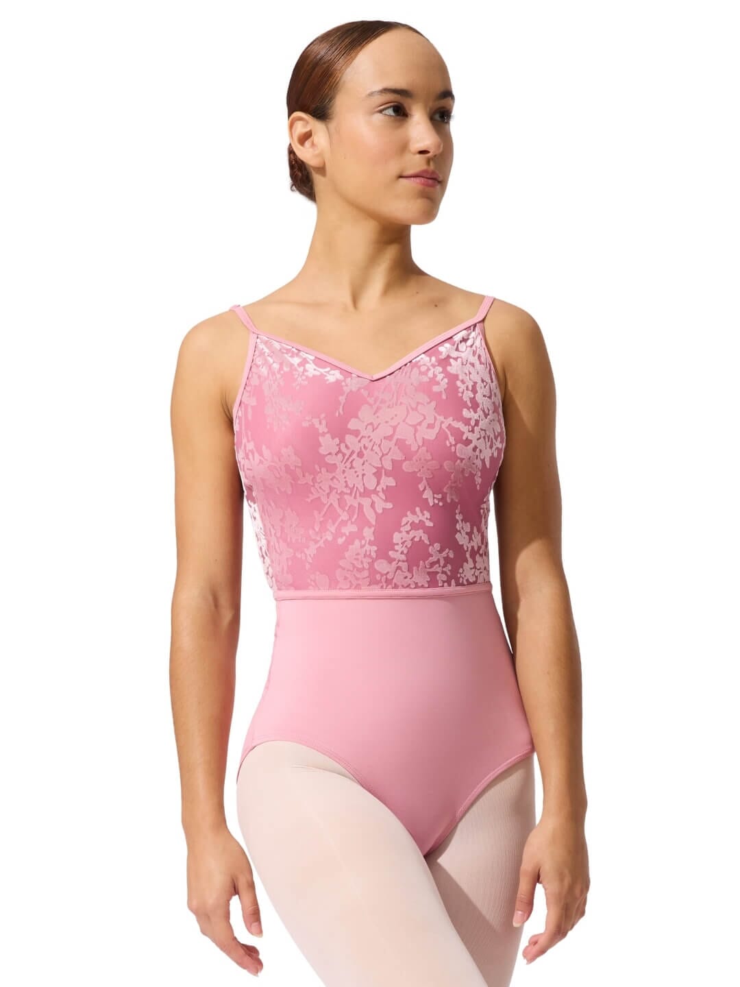 Woman wearing a pink ballet leotard with lace details on a white background