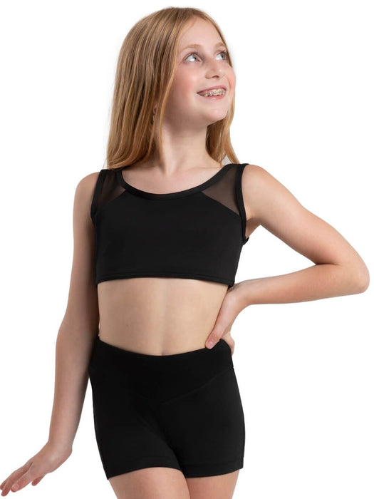Young girl wearing a black crop top and shorts on a white background