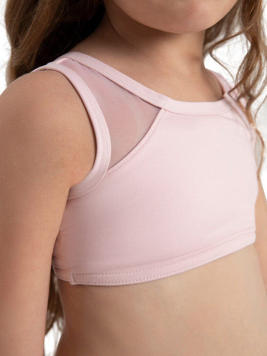 Pink sports bra with mesh panels worn by a person