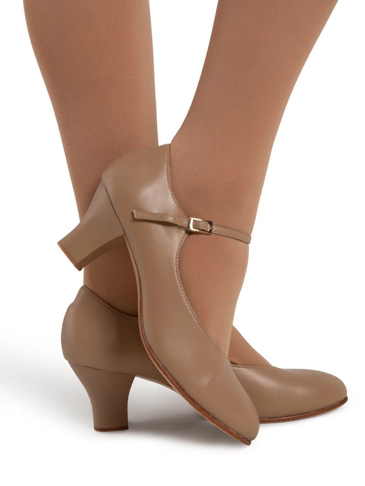 Brown heeled shoes with a bow detail worn by a person on a white background