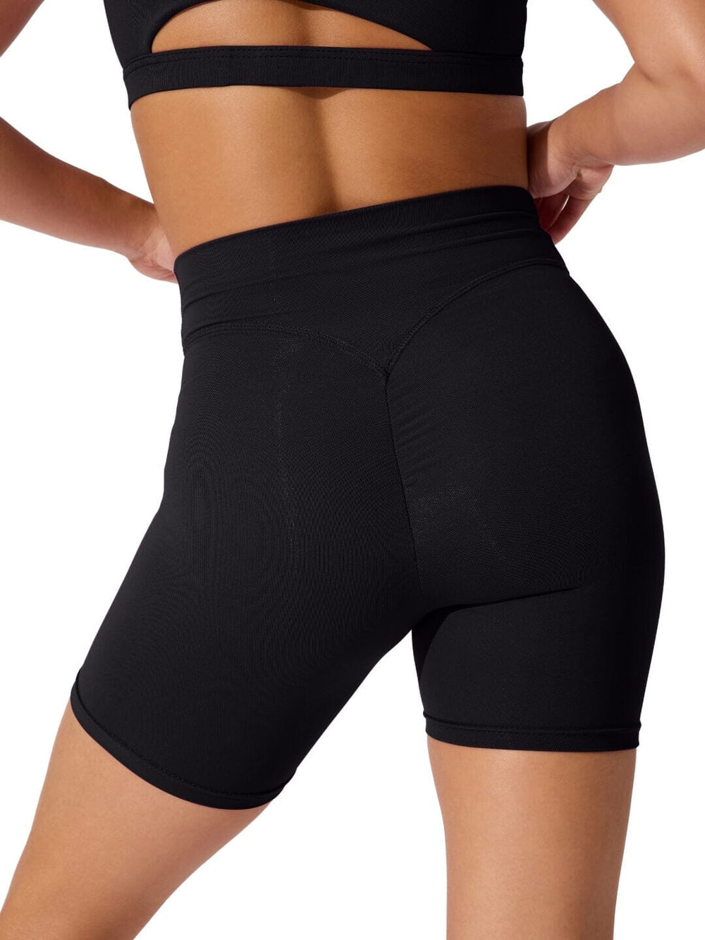Black athletic shorts worn by a person on a white background
