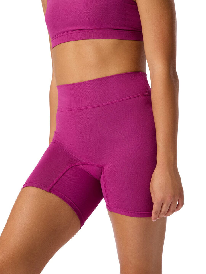Purple athletic shorts worn by a person on a white background