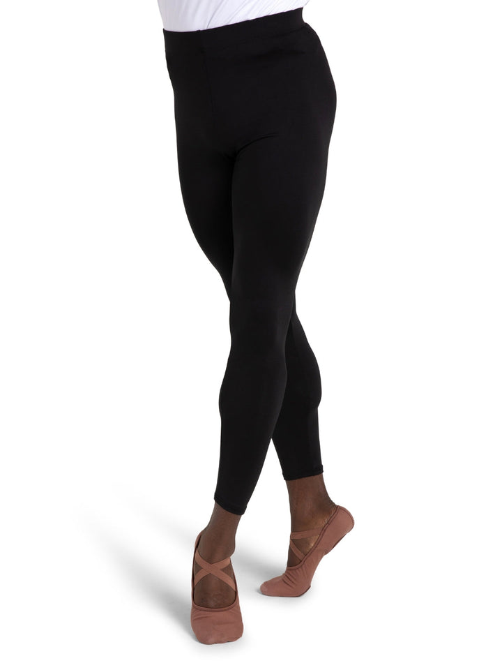 Person wearing black leggings and brown ballet shoes on a white background