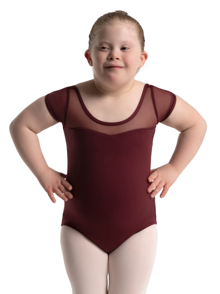 Child wearing a maroon leotard on a white background