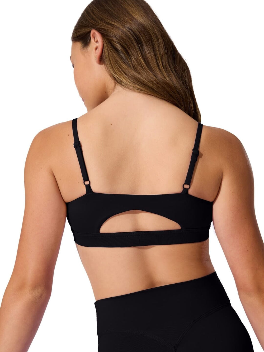 Black sports bra worn by a person on a white background