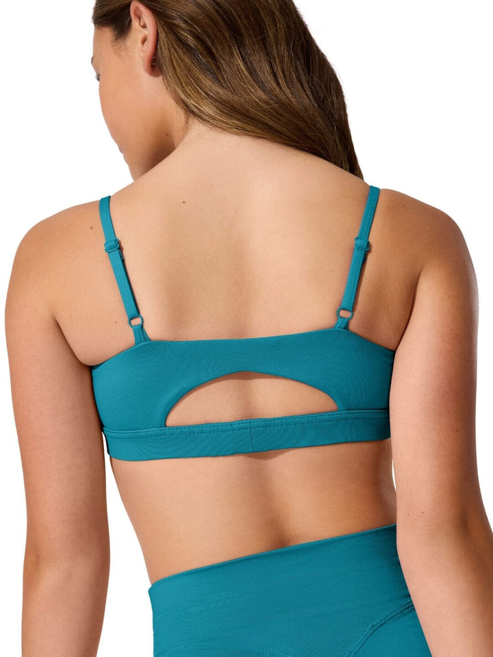 Teal sports bra worn by a person on a white background