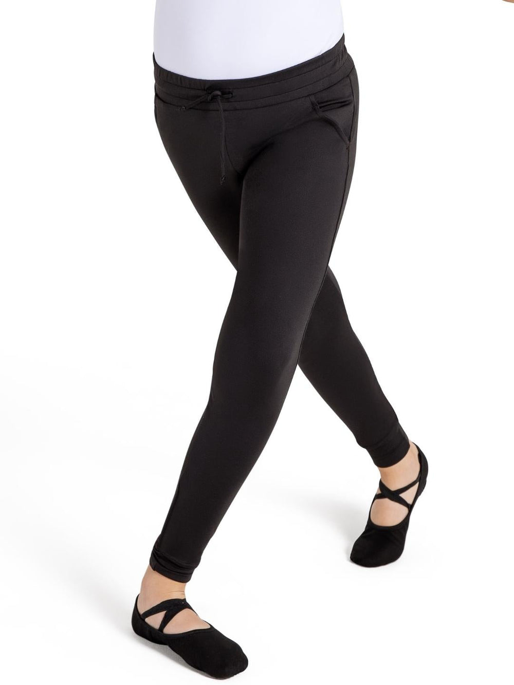 Person wearing black leggings and black ballet shoes on a white background