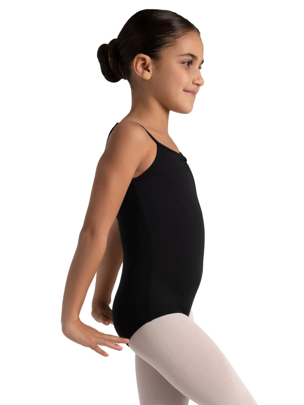 Young girl in a black leotard and white tights posing against a white background