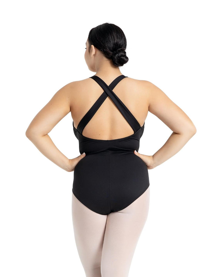 Person wearing a black leotard with criss-cross straps on a white background