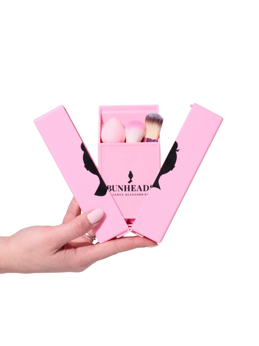 Pink makeup box with brushes and eggs, held by a hand on a white background