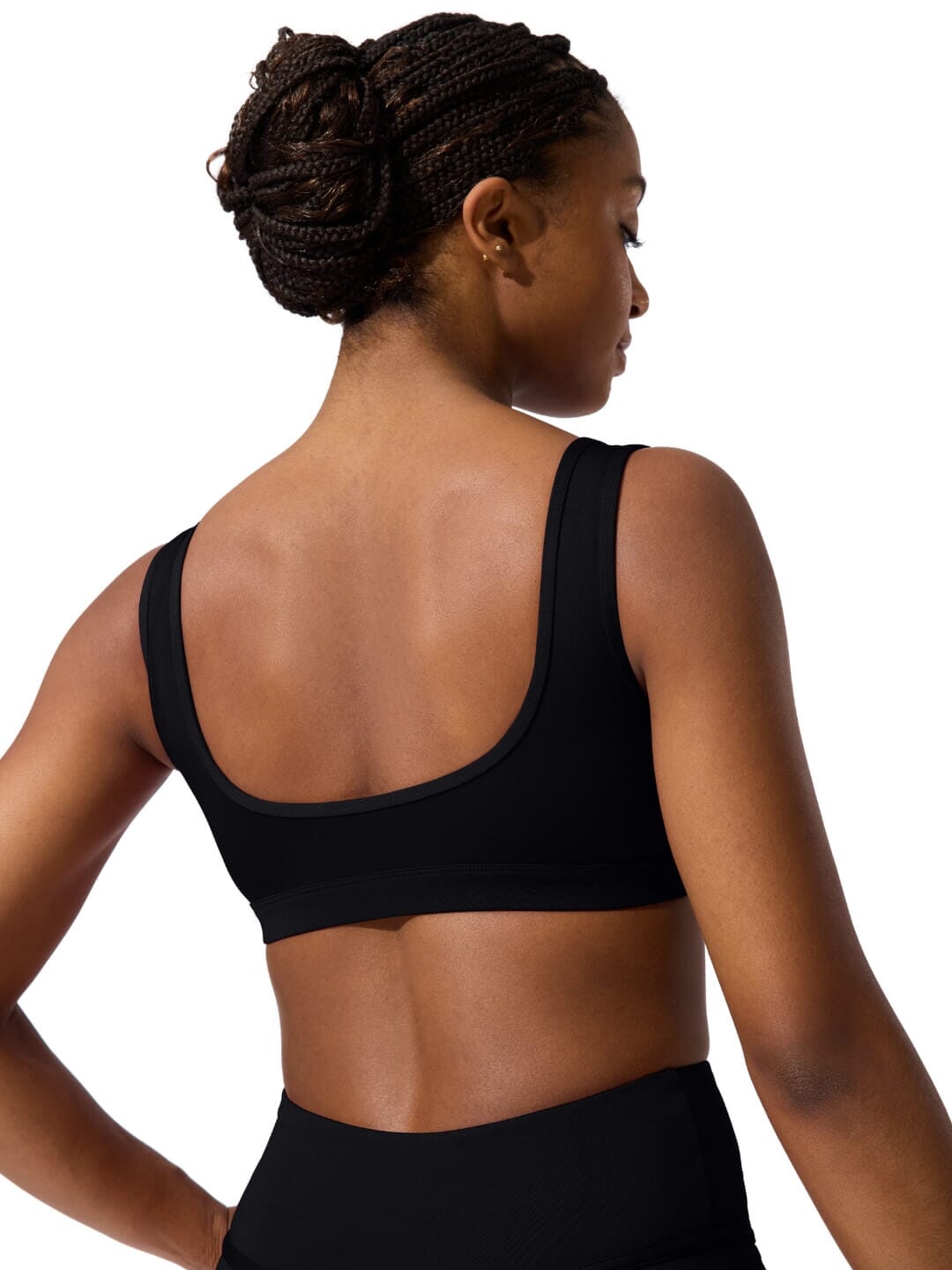 Woman wearing a black sports bra and leggings on a white background