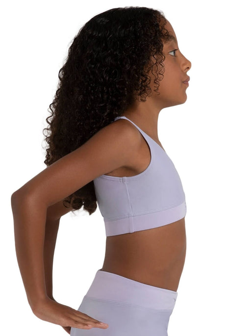 Woman wearing a light purple sports bra and leggings on a white background