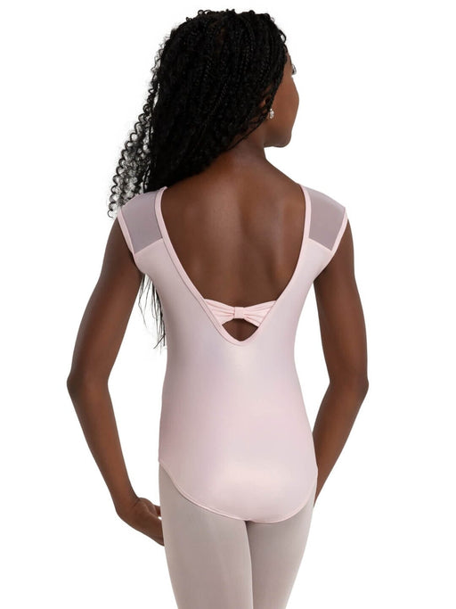 Woman wearing a light pink leotard with mesh panels on a white background