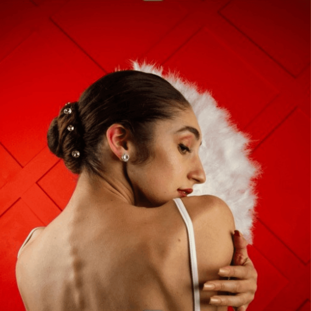 Woman with a white feathered headpiece against a red background