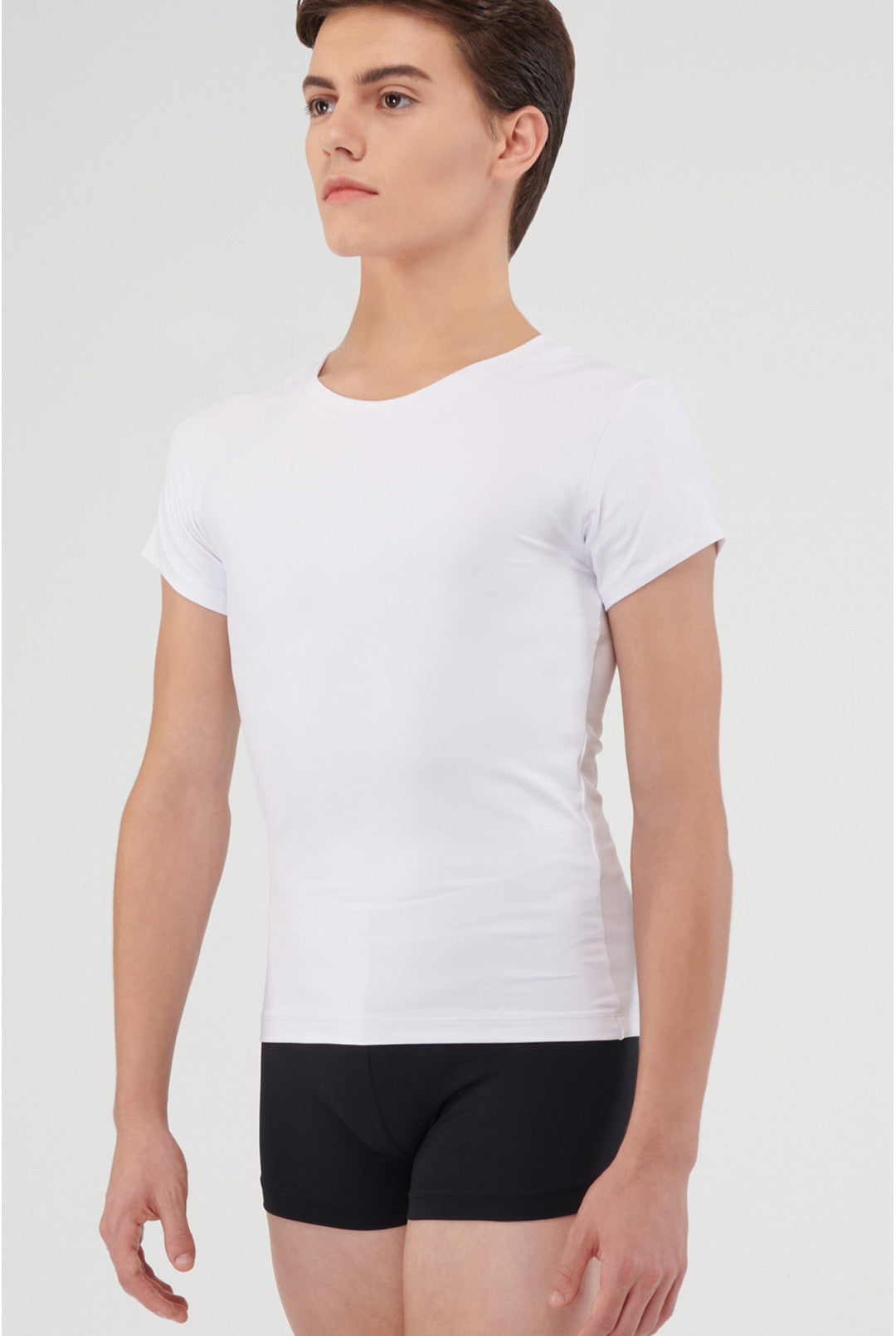 Person wearing a plain white t-shirt and black shorts on a light gray background