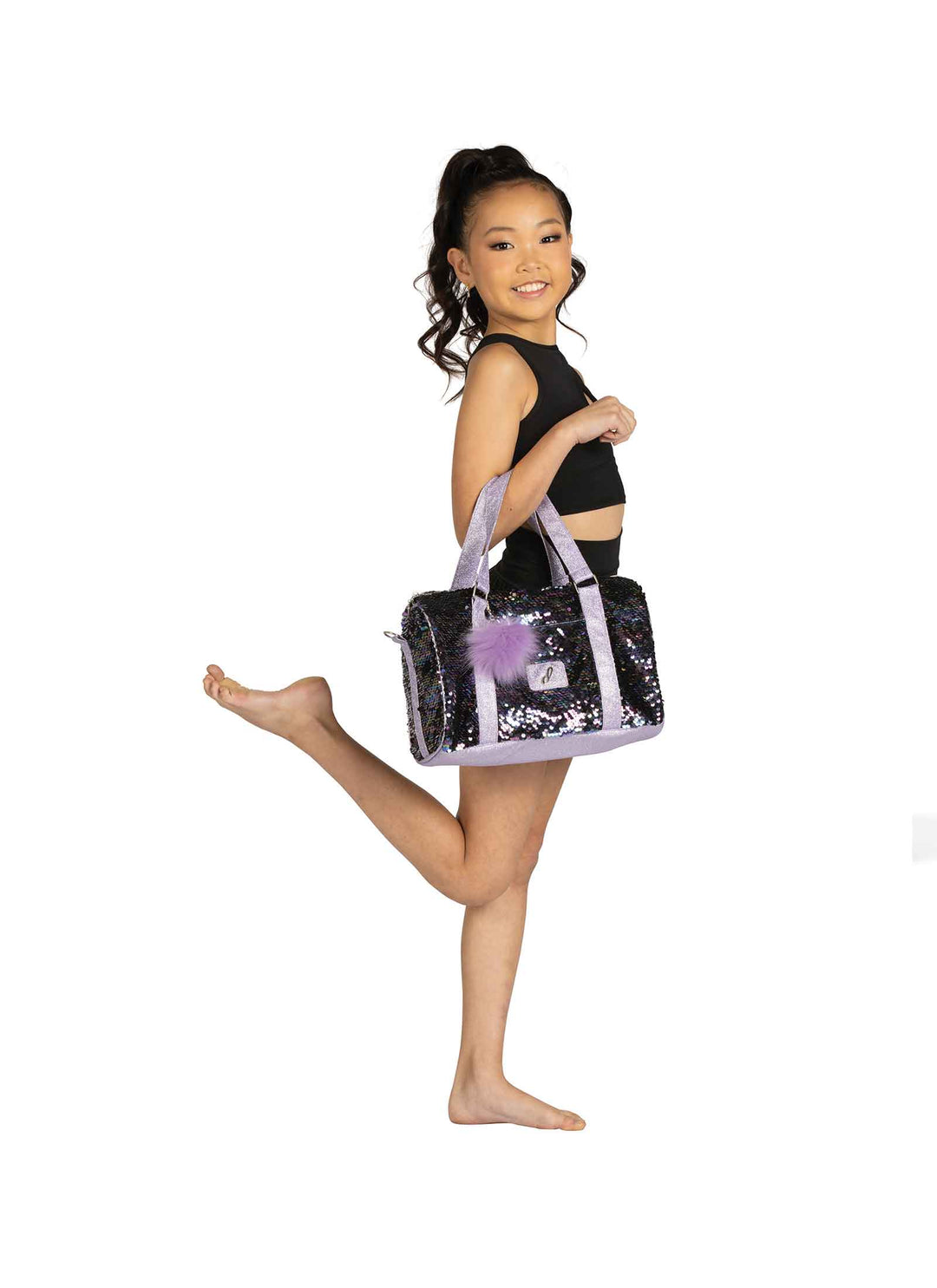 Young girl in a black outfit with a sequin bag on a white background