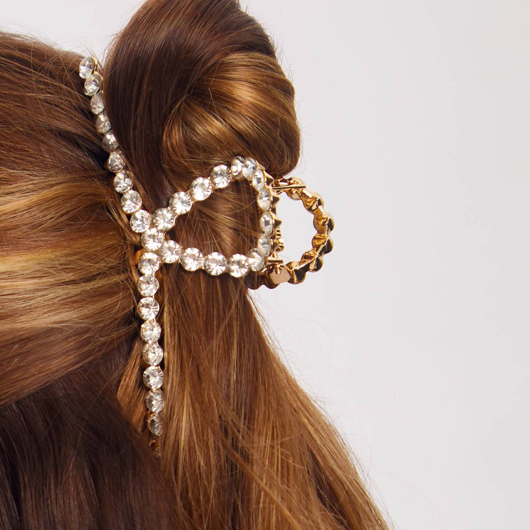 Elegant hair accessory with crystals and gold elements in a styled hair on a plain background