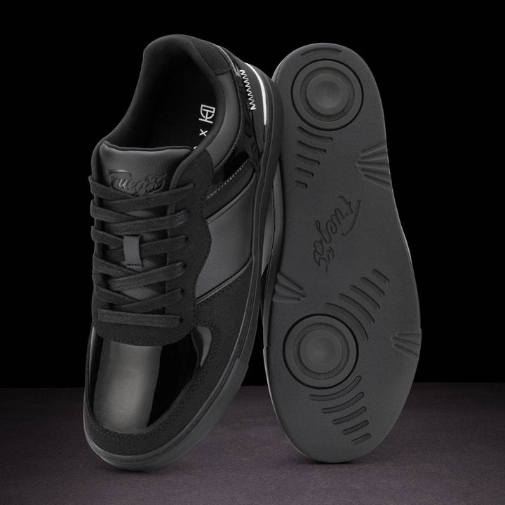 Black dance shoe with sole showing brand name on a dark background