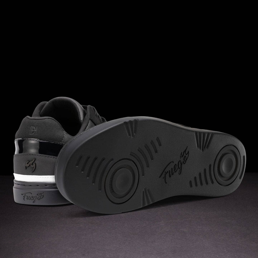 Black sneaker with sole showing brand name on a dark background