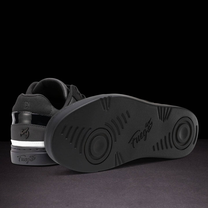 Black sneaker with sole showing brand name on a dark background