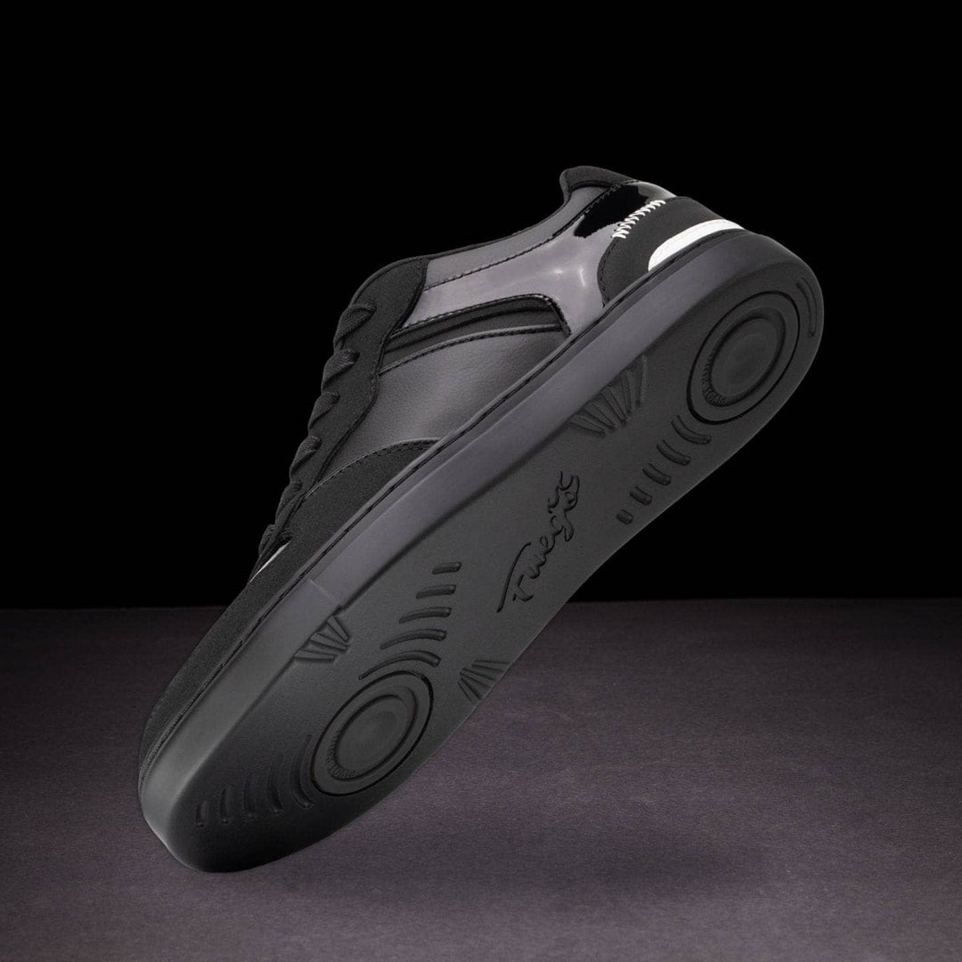 Gray sneaker with black sole on a dark background