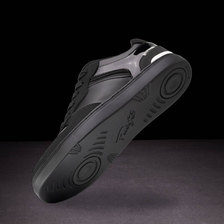 Gray sneaker with black sole on a dark background