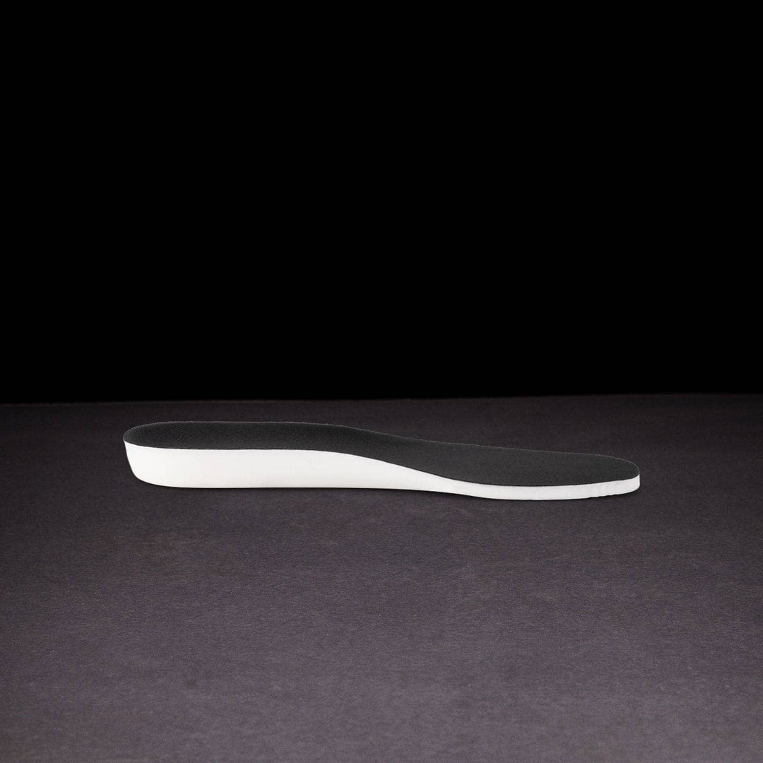 Black and white shoe insole on a dark background