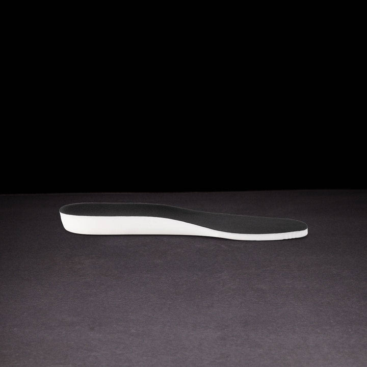 Black and white shoe insole on a dark background