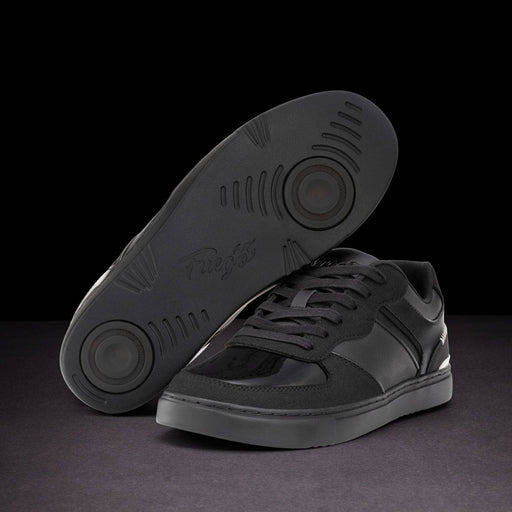Black sneaker with sole showing brand name on a dark background