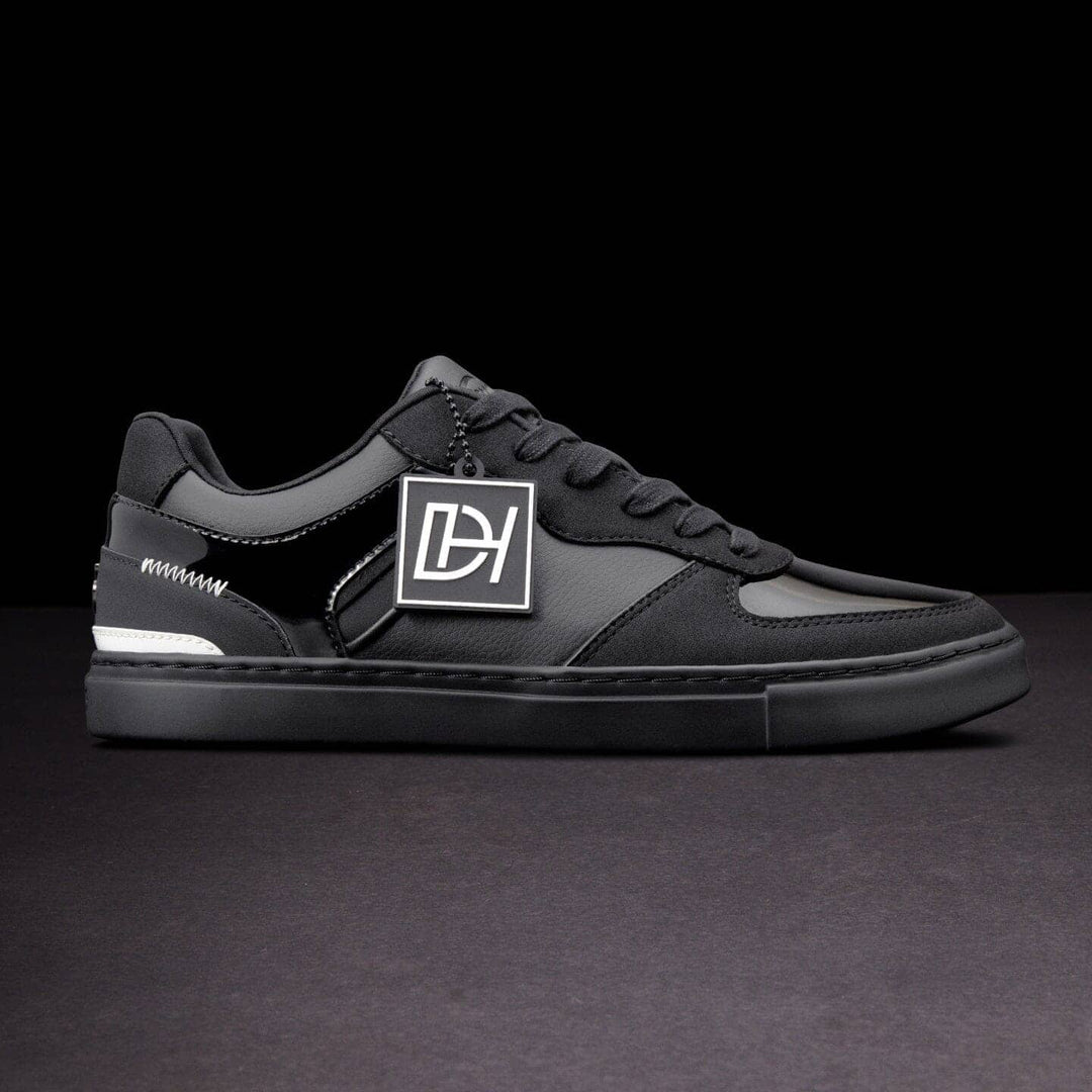 Black sneaker with a logo on a dark background